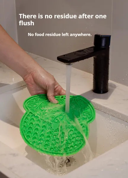 Green suction lick mat being rinsed clean