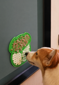 Dog licking food from a green suction lick mat